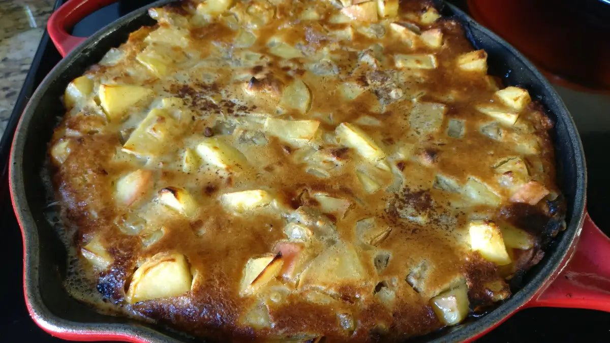 A cast iron skillet filled with a Savory Apple Skillet Cake for breakfast.