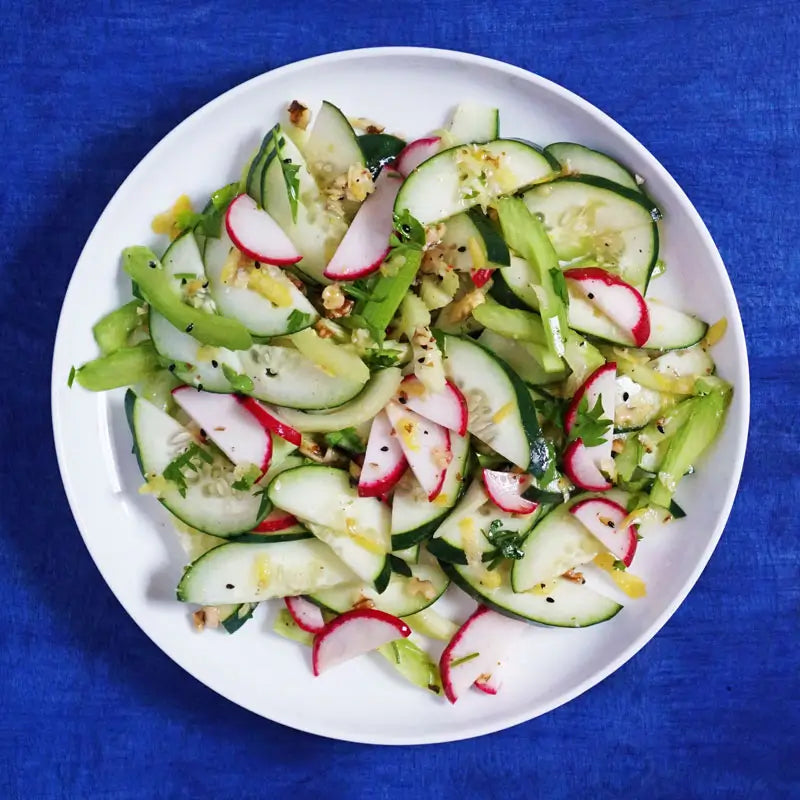 Birds eye view of cucumber salad featuring organic PrimalOil and organic black cumin seeds