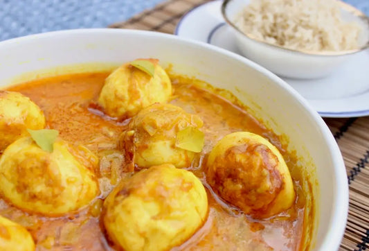 A bowl of golden egg curry made with our organic Grassfed ghee and organic dried curry leaves.