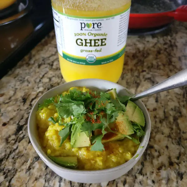 A bowl of instant pot kitchari next to a large jar of our Organic Grassfed Ghee.