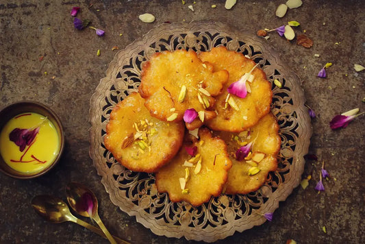 A birds eye view of a plate of Indian ricotta pancakes with a saffron cardamom syrup.