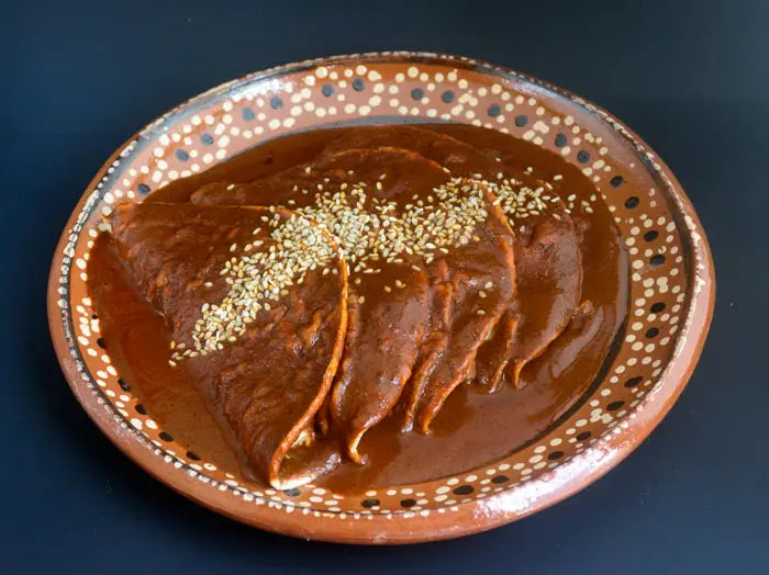 A plate of quesadillas topped with mole sauce