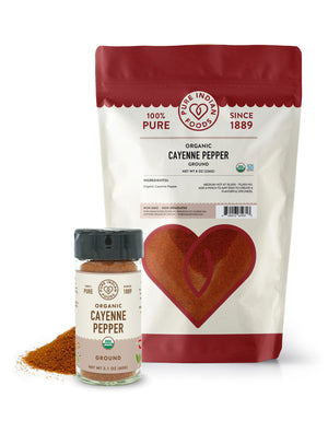 One 8 oz bag and one 2.1 oz jar of organic cayenne pepper from Pure Indian Foods sit side by side on a white surface
