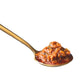 On a white background, a red, full spoonful of spicy pickled garlic achaar sits in a golden spoon.