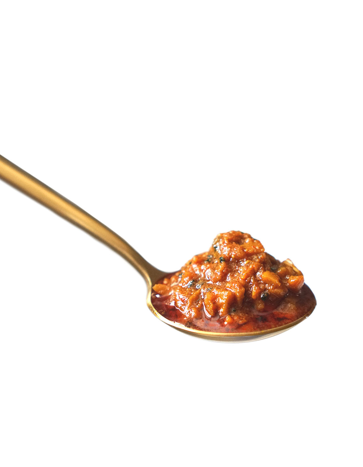 On a white background, a red, full spoonful of spicy pickled garlic achaar sits in a golden spoon.