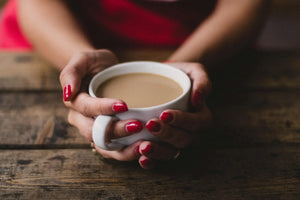 A warm cup of Ojas Hot Cocoa being held in someones hands.