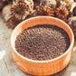 a wooden bowl full of organic poppy seeds