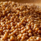 A close up of organic yellow mustard seeds in a wooden bowl